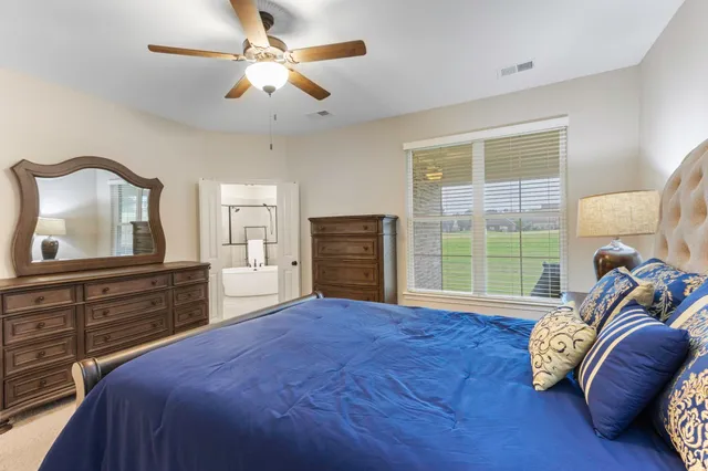 a bedroom with a bed and a large window