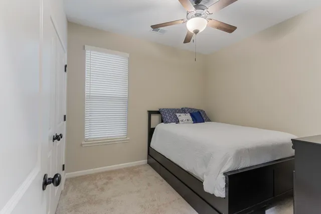 a bed sitting in a bedroom next to a window and a chandelier