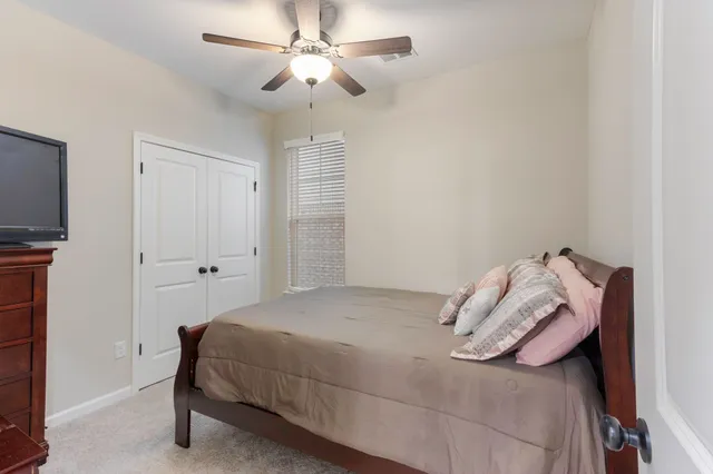 a bedroom with a bed and a ceiling fan