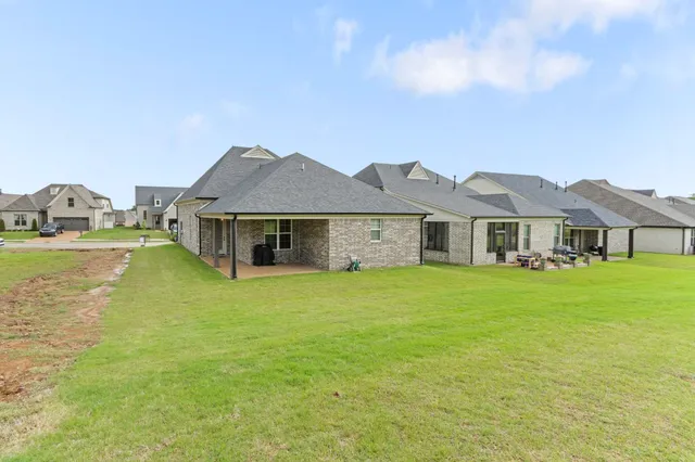a front view of a house with a garden and yard