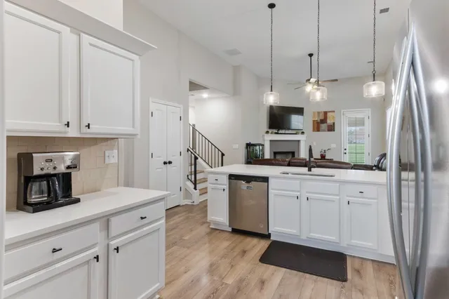 a kitchen with kitchen island granite countertop a sink a counter top space stainless steel appliances and cabinets