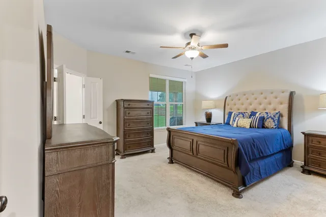 a bed room with a bed and a ceiling fan