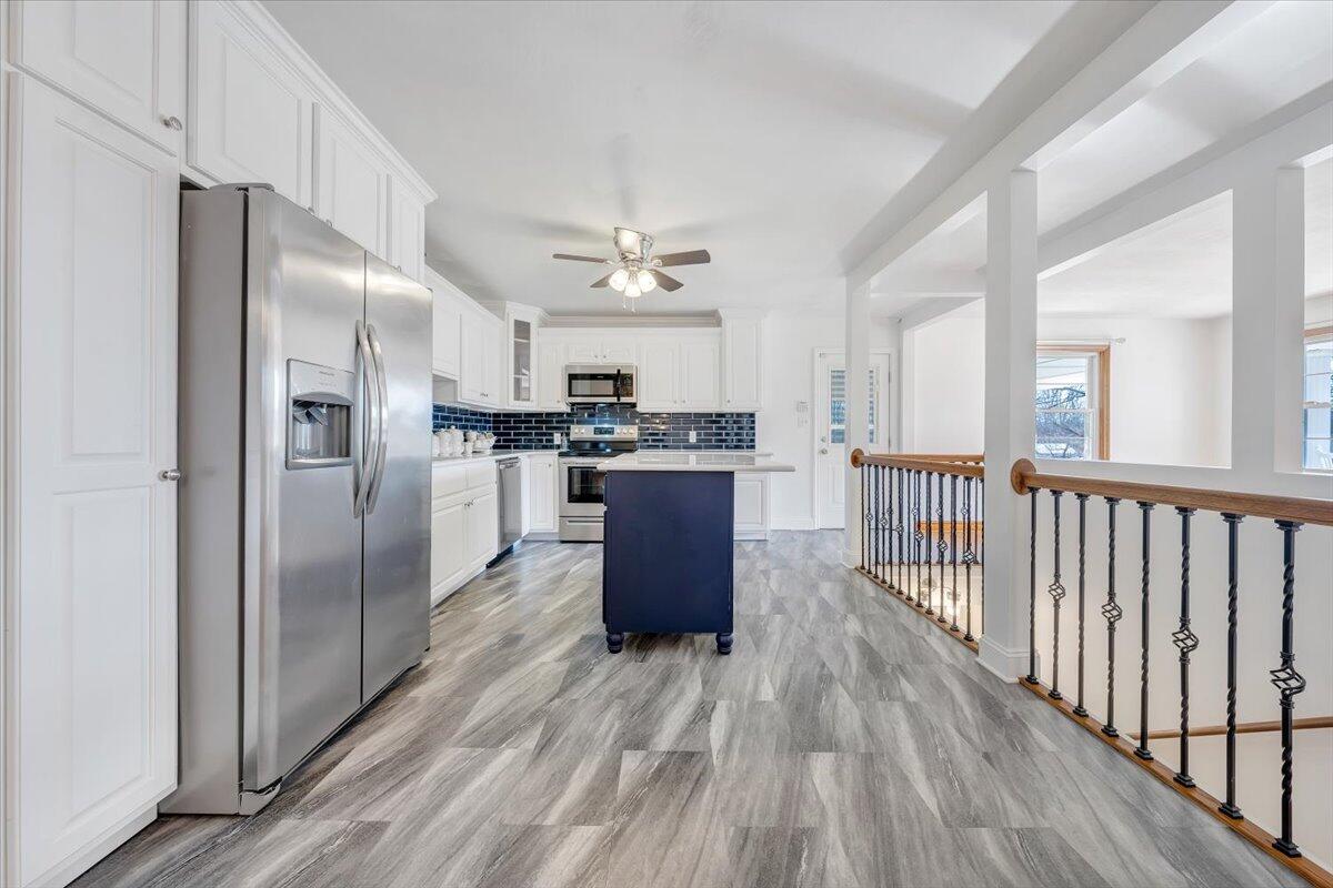 3400 Dillons Fork Road Fieldale, VA 24089 - Photo 6 of 45 a kitchen with stainless steel appliances a refrigerator a sink dishwasher a stove and white cabinets with wooden floor