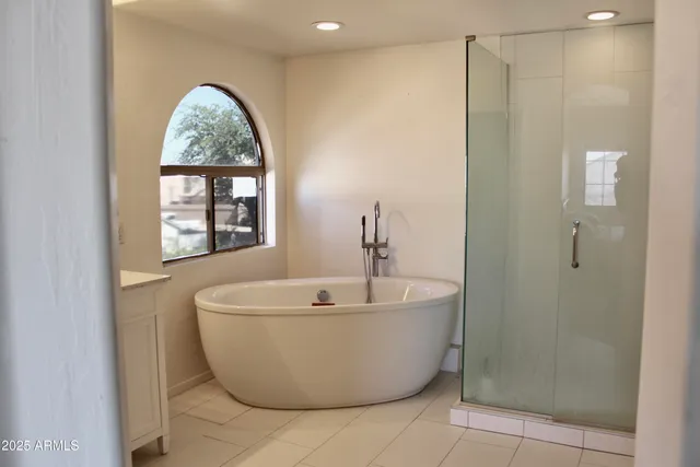 a bedroom with a bed and a flat tv screen on dresser