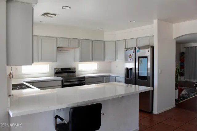 a kitchen with granite countertop a sink a stove and cabinets