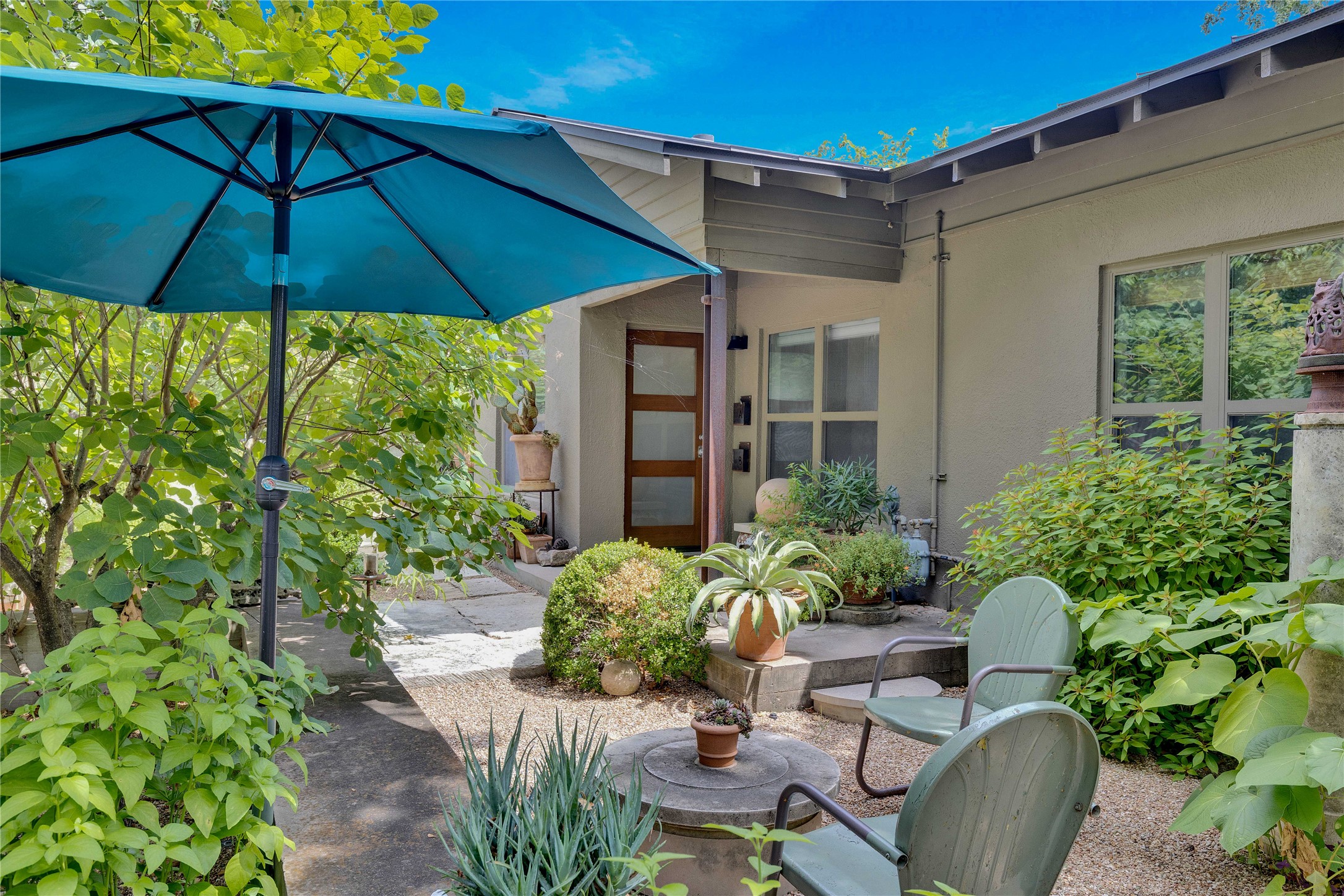 1306 Norwood Road, Unit A Austin, TX 78722 - Photo 4 of 21 An inviting front patio with mature landscaping welcomes you home.