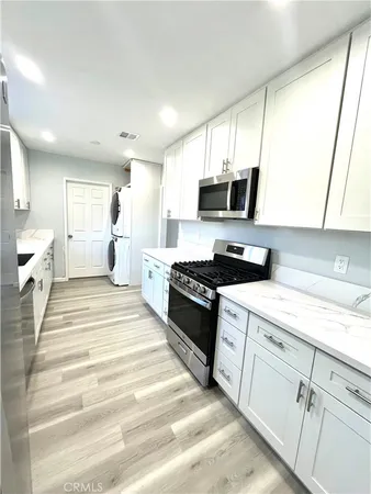 a large white kitchen with stainless steel appliances