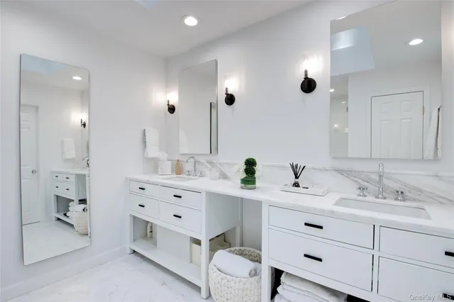 a bathroom with a double vanity sink mirror and shower