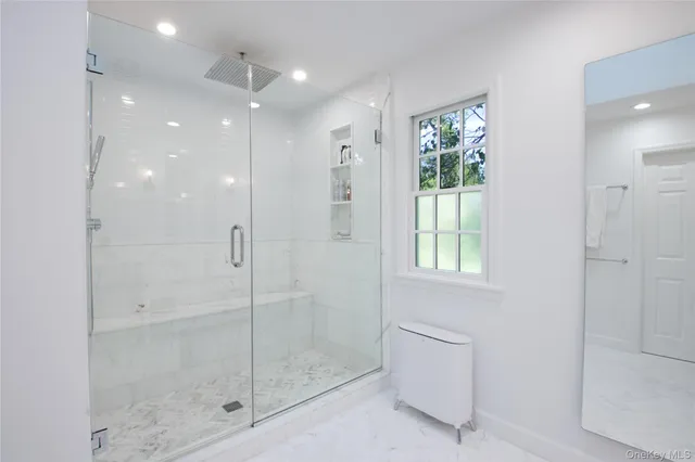 a bathroom with a shower and a glass door