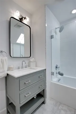 a bathroom with a tub sink and mirror