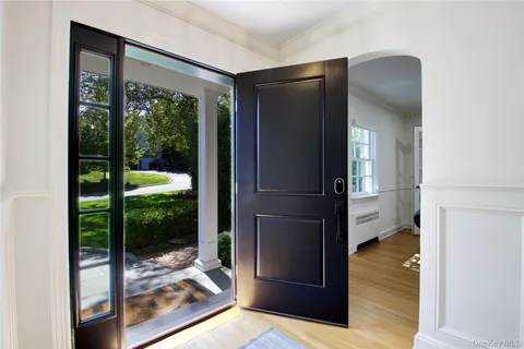 a view of hallway with living room and floor to ceiling window