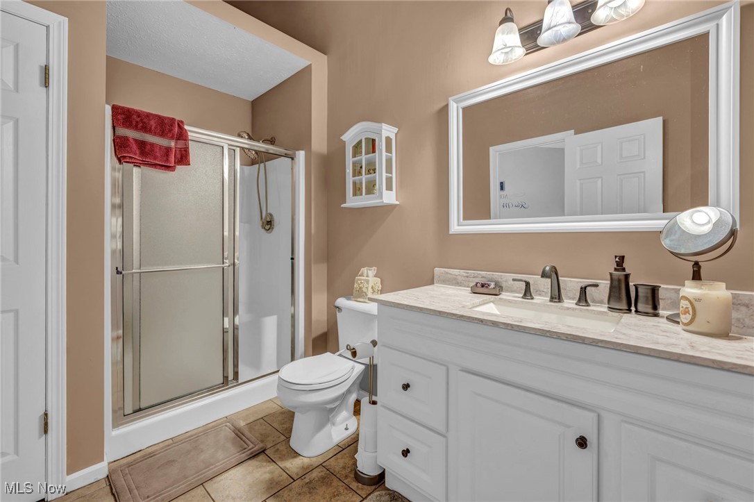3887 Reeves Lane Medina, OH 44256 - Photo 38 of 42 Bathroom featuring tile patterned floors, vanity, toilet, and walk in shower