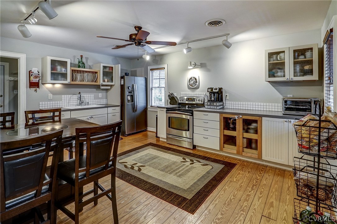 7206 Barkbridge Road Chesterfield, VA 23832 - Photo 3 of 36 a kitchen with stainless steel appliances granite countertop a stove top oven a sink dishwasher a dining table and chairs with wooden floor
