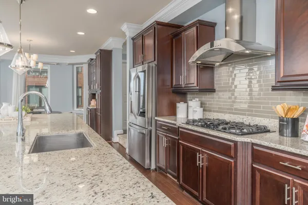 a kitchen with stainless steel appliances granite countertop a sink stove and refrigerator