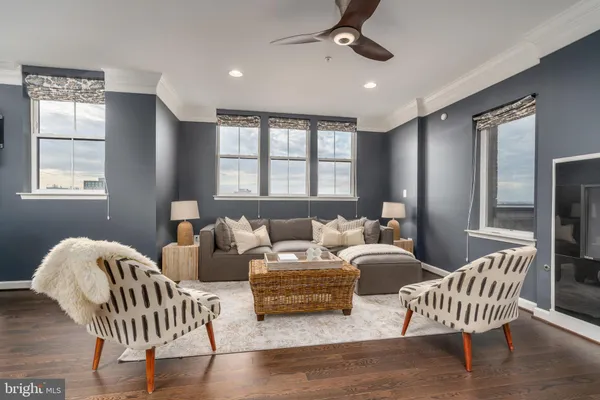 a living room with furniture a window and wooden floor
