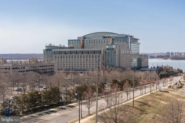 a living room with furniture floor to ceiling window and wooden floor
