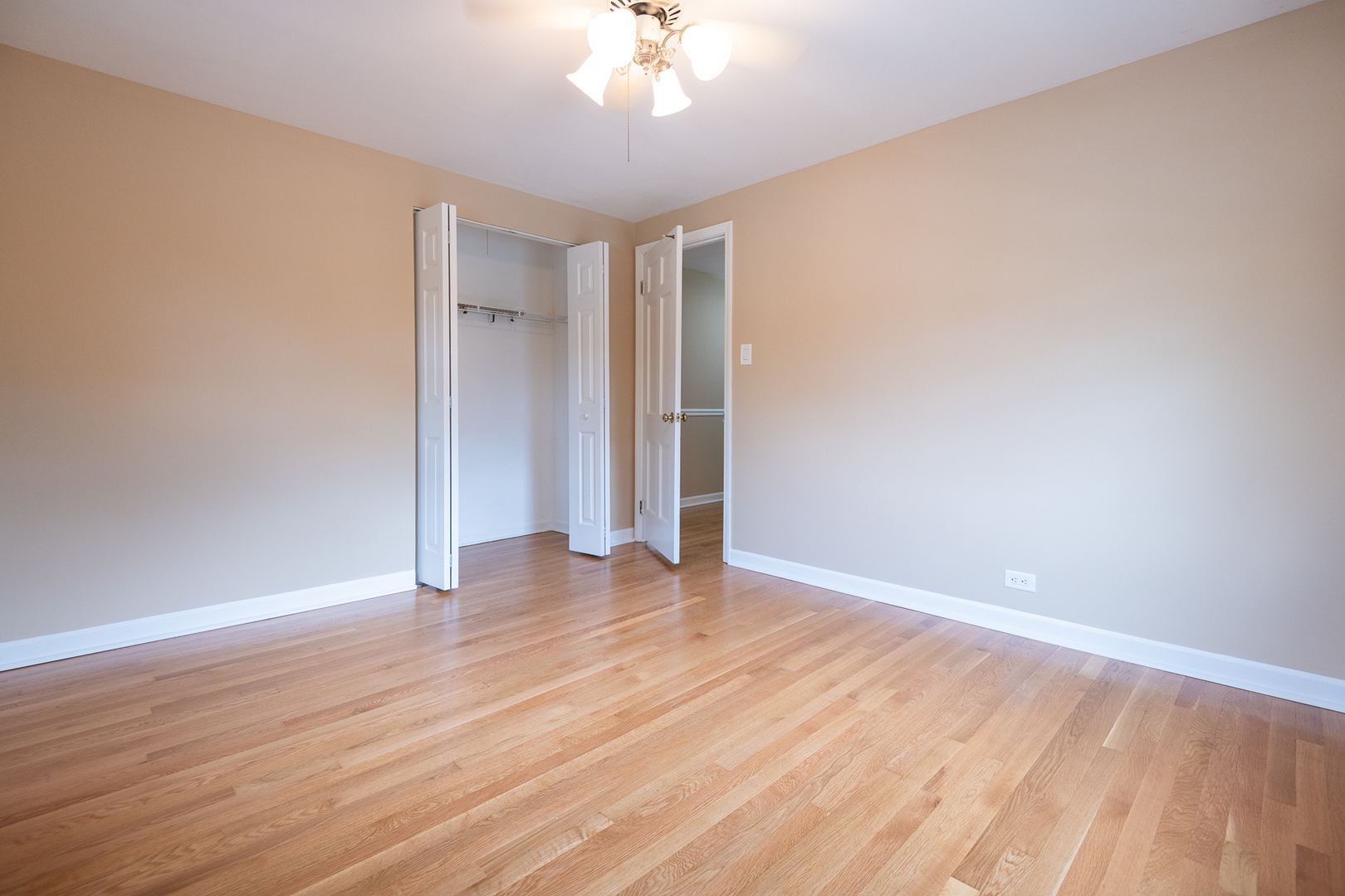 227 Country Club Drive Addison, IL 60101 - Photo 28 of 39 a view of an empty room with wooden floor and a ceiling fan