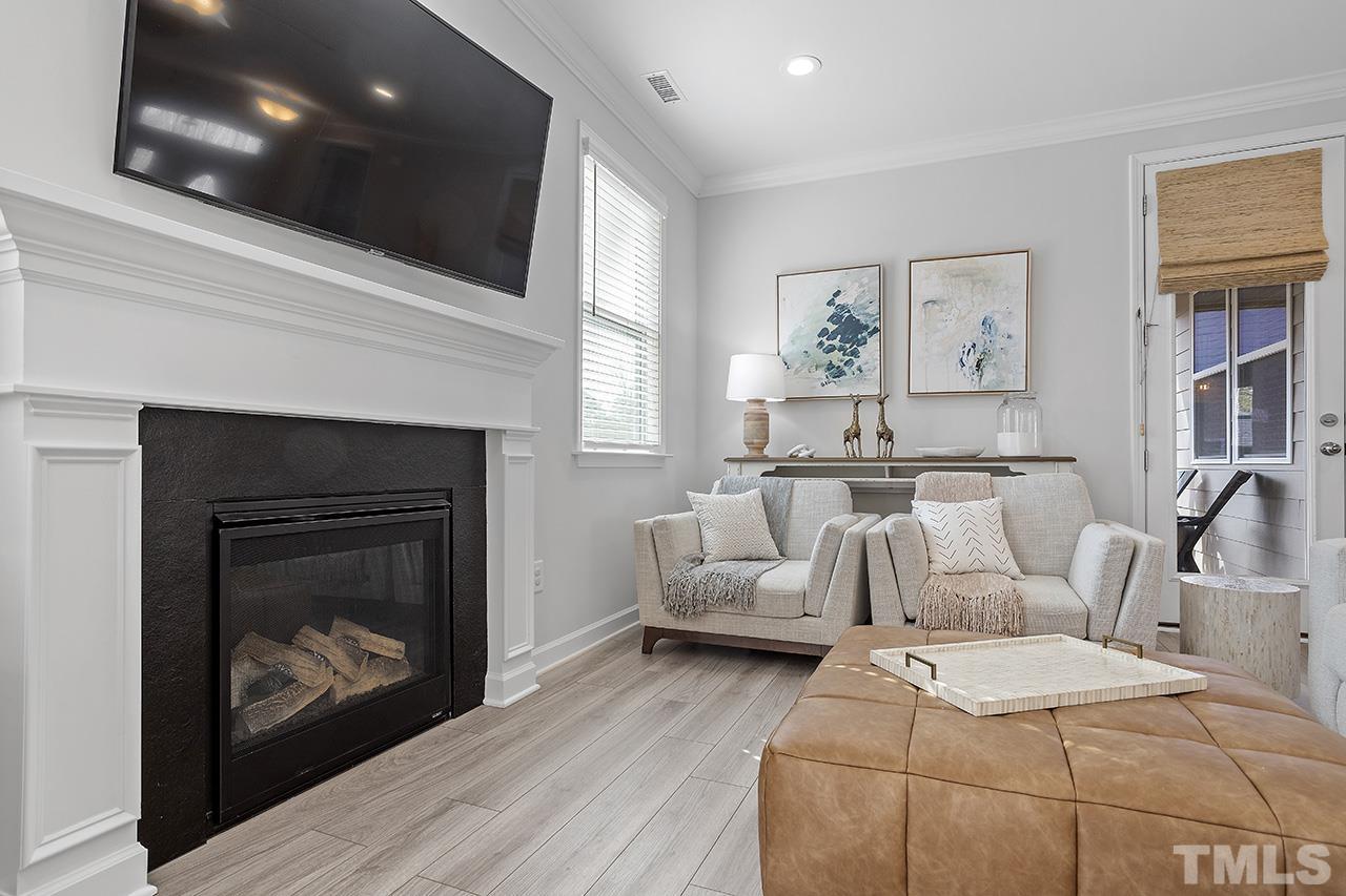 1445 Commons Ford Place Apex, NC 27539 - Photo 12 of 34 a living room with furniture a fireplace and a flat screen tv
