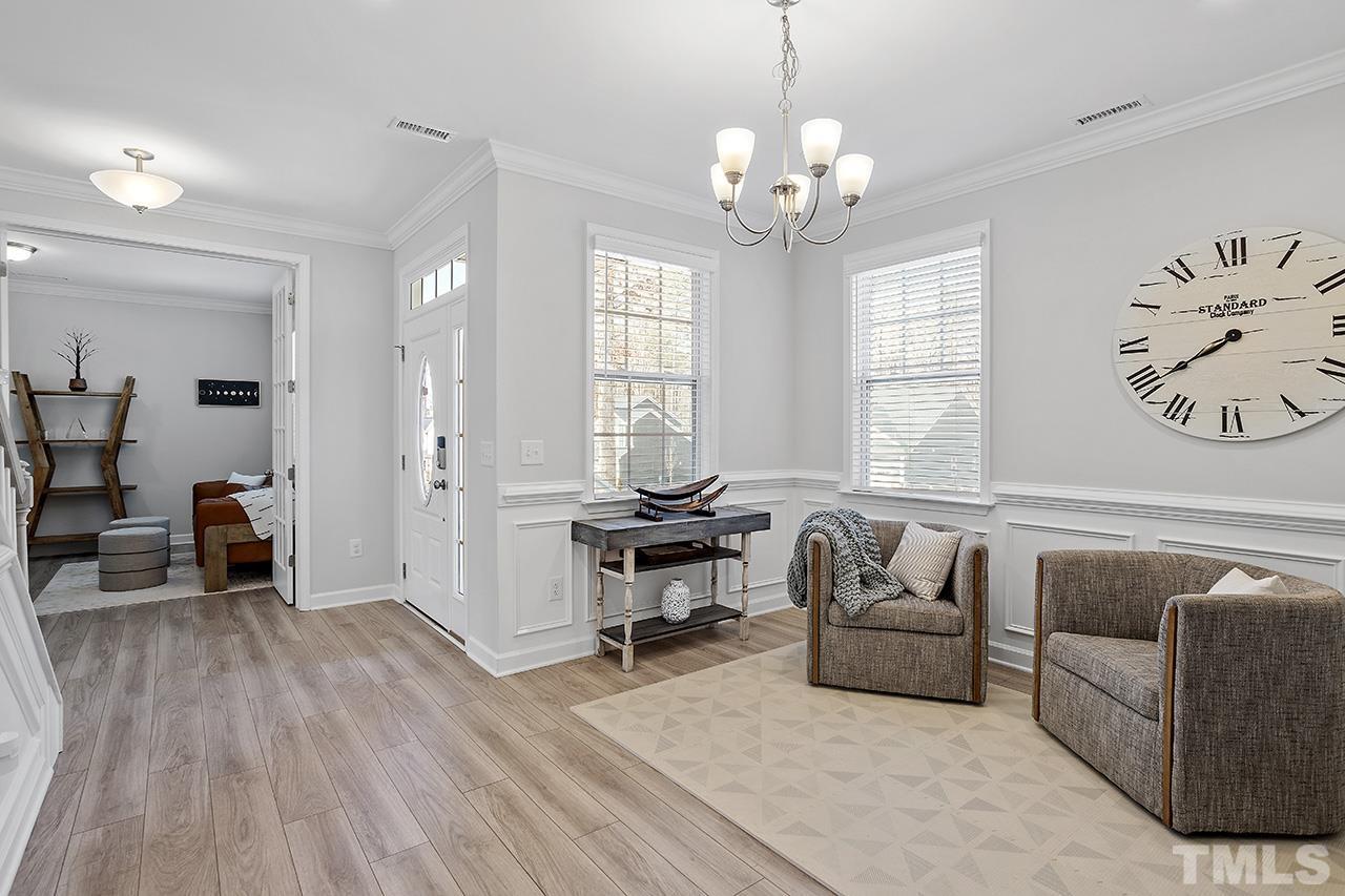 1445 Commons Ford Place Apex, NC 27539 - Photo 16 of 34 a living room with furniture and a chandelier