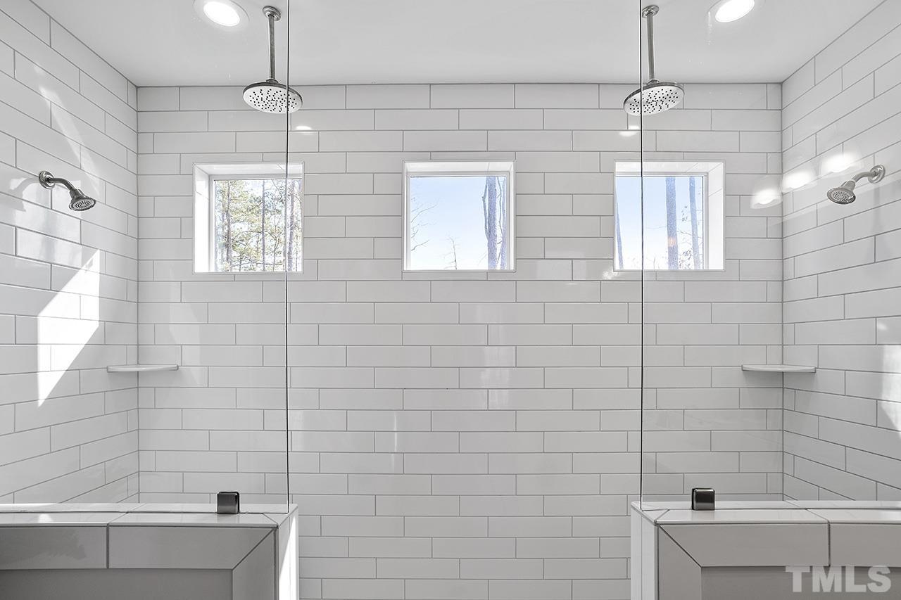 1445 Commons Ford Place Apex, NC 27539 - Photo 25 of 34 a bathroom with a bathtub shower sink and mirror