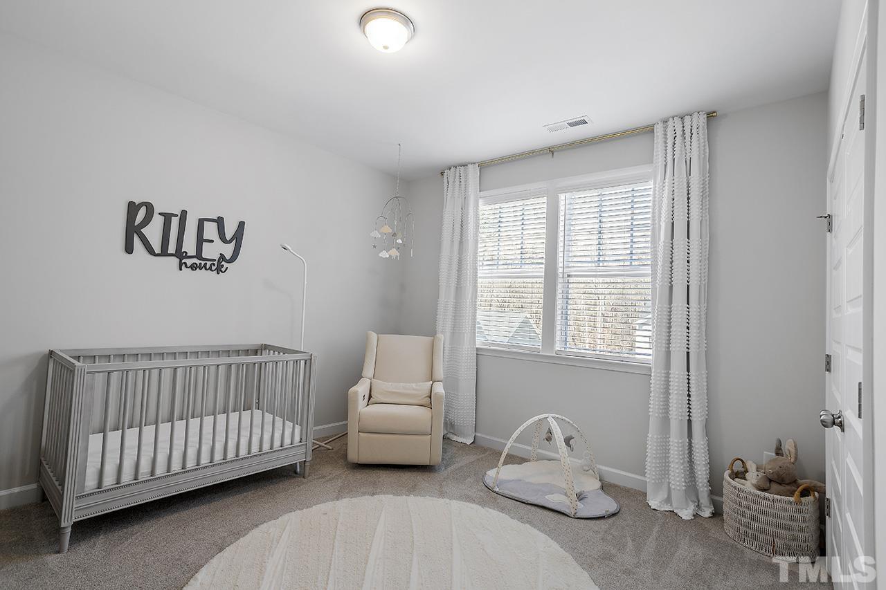 1445 Commons Ford Place Apex, NC 27539 - Photo 28 of 34 a bedroom with furniture and a window