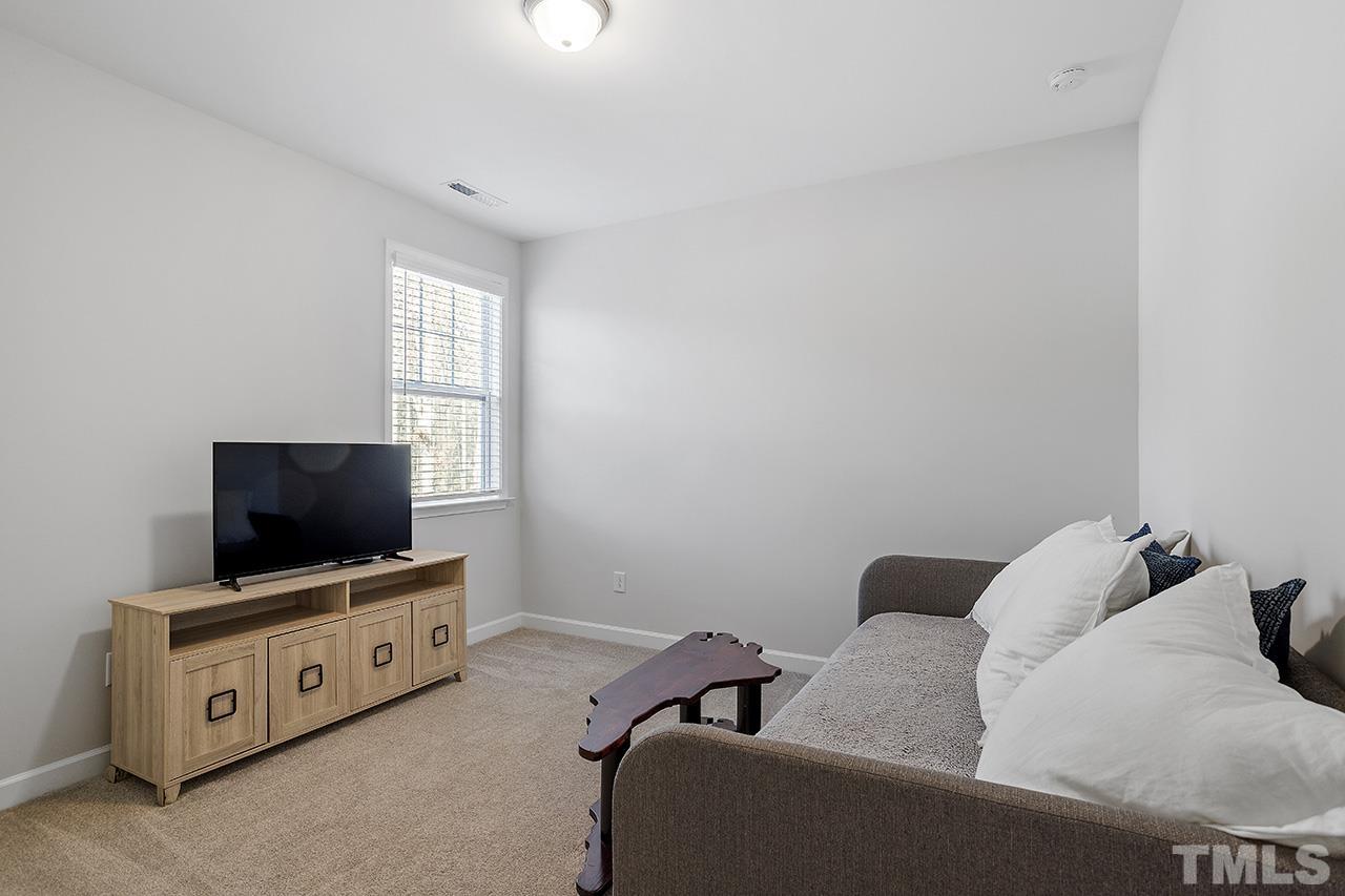 1445 Commons Ford Place Apex, NC 27539 - Photo 29 of 34 a living room with furniture and a flat screen tv