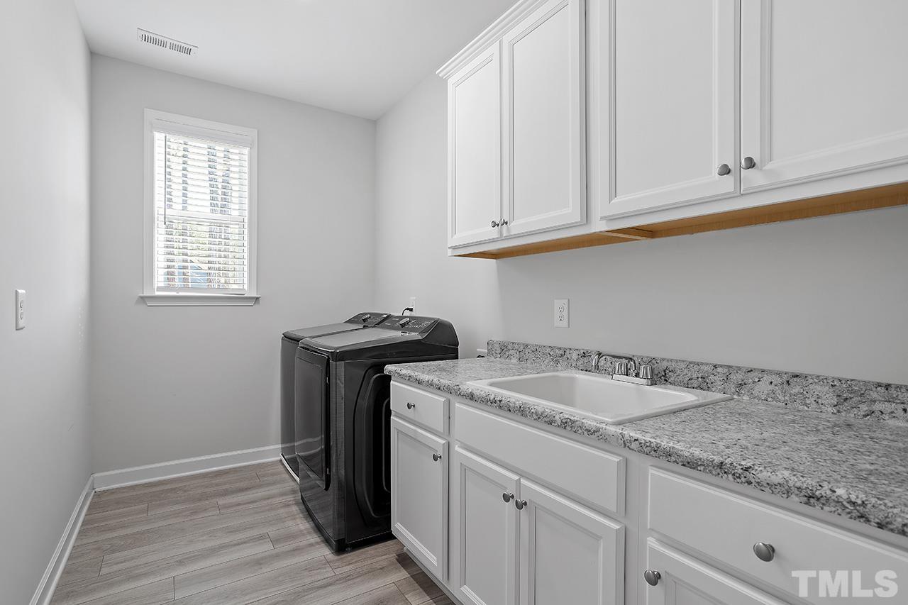 1445 Commons Ford Place Apex, NC 27539 - Photo 30 of 34 a kitchen with granite countertop white cabinets and a sink