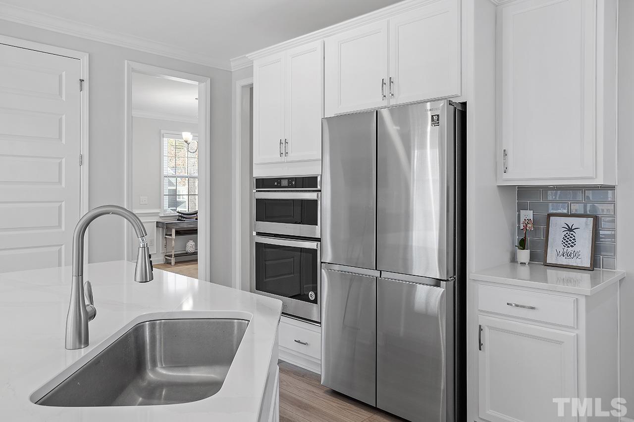 1445 Commons Ford Place Apex, NC 27539 - Photo 7 of 34 a kitchen with a refrigerator sink and cabinets