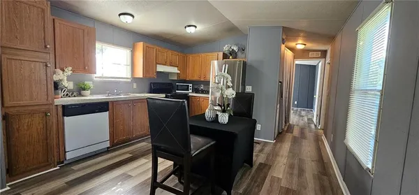 a kitchen with a table chairs refrigerator and microwave