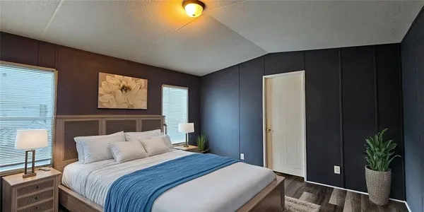 a bedroom with bed and a potted plant