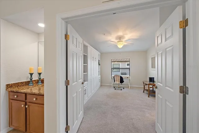 a view of a hallway with workspace and a window