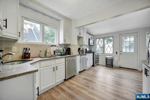 a kitchen with sink a window and cabinets