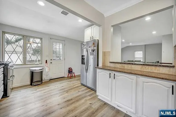 a large kitchen with a lot of counter space and wooden floor