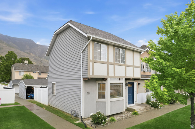 1099 South 950 East, Unit 17 Provo, UT 84606 - Photo 3 of 23 Two-story townhome with a light gray siding exterior, contrasting half-timber detailing, and a prominent blue entry door