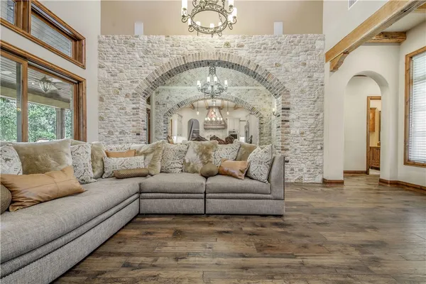 a living room with furniture a large window and a chandelier