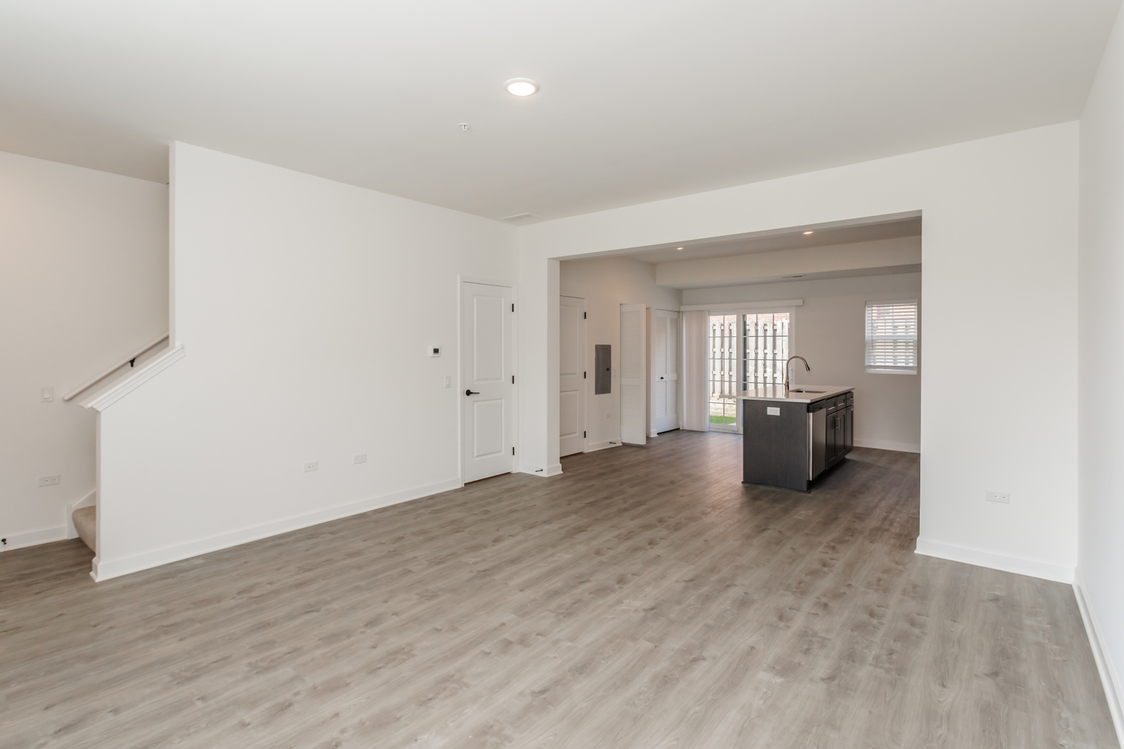 1432 North Naperville Wheaton Road, Unit 114 Naperville, IL 60563 - Photo 5 of 15 a view of an empty room with wooden floor and a kitchen