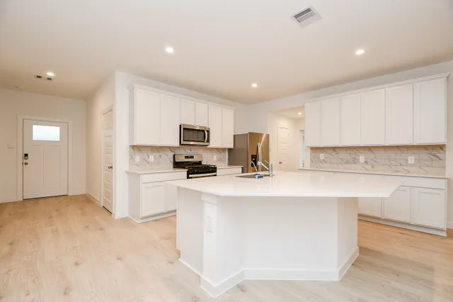 a kitchen with stainless steel appliances granite countertop a sink stove oven and refrigerator