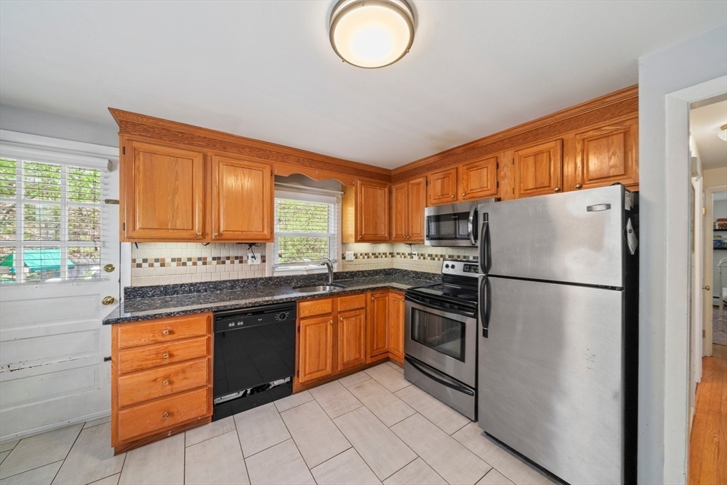 55 Running Brook Road Boston, MA 02132 - Photo 12 of 32 a kitchen with stainless steel appliances granite countertop a refrigerator sink and stove