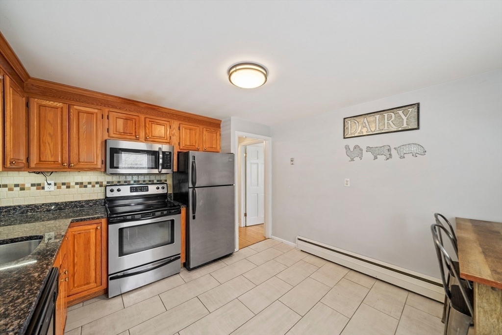55 Running Brook Road Boston, MA 02132 - Photo 14 of 32 a kitchen with granite countertop a refrigerator stove and microwave