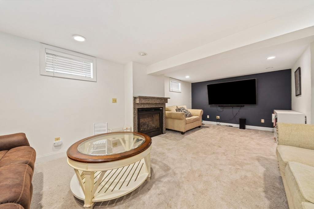 55 Running Brook Road Boston, MA 02132 - Photo 23 of 32 a living room with furniture and a flat screen tv