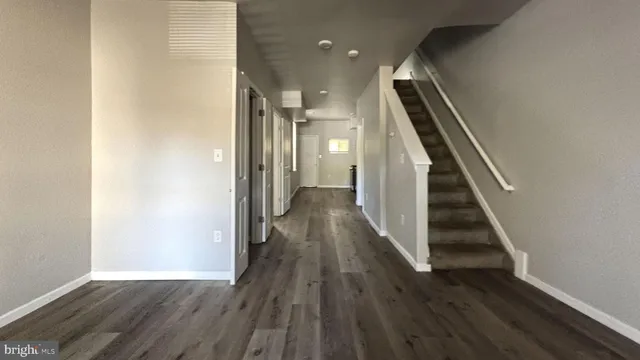 a view of a hallway with wooden floor and staircase