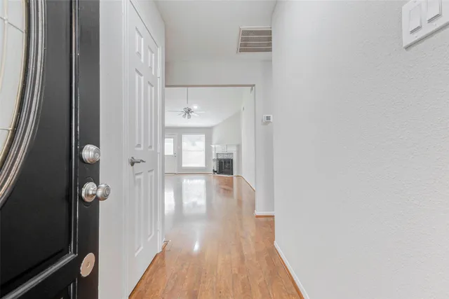 a view of a hallway with wooden floor and staircase
