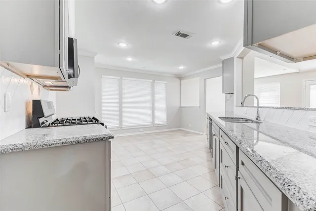 a kitchen with a sink stove and cabinets