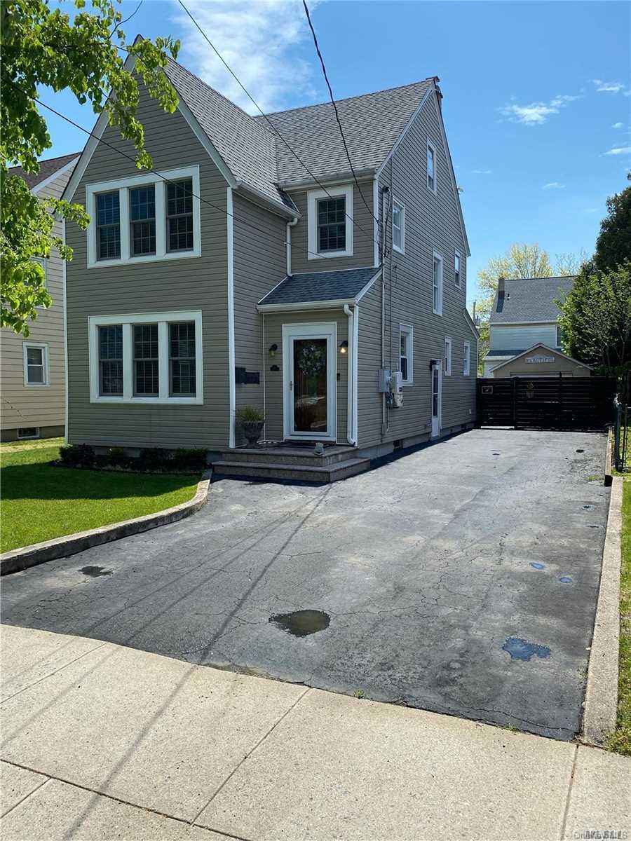 82 Jackson Road Valley Stream, NY 11581 - Photo 1 of 1 a front view of a house with a yard and garage