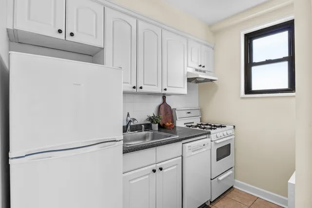 a kitchen with stainless steel appliances white cabinets and a refrigerator