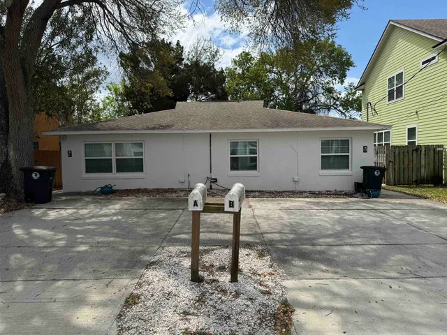 a backyard of a house with table and chairs
