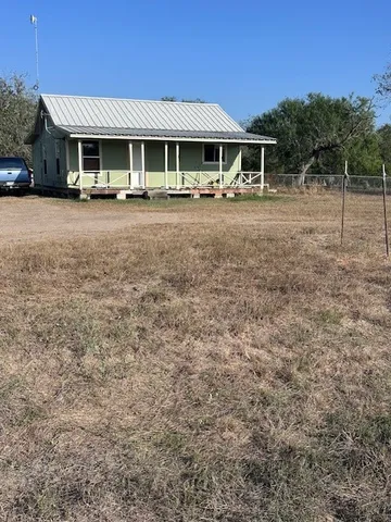 a view of a house with backyard and trees