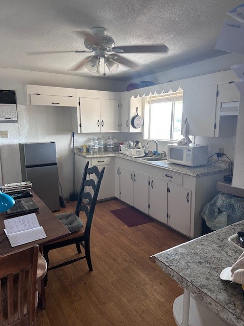 5452 Fm 666 Street Mathis, TX 78368 - Photo 5 of 17 a kitchen with granite countertop a sink a stove a dining table and chairs