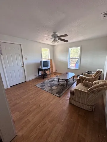 a living room with furniture window and wooden floor