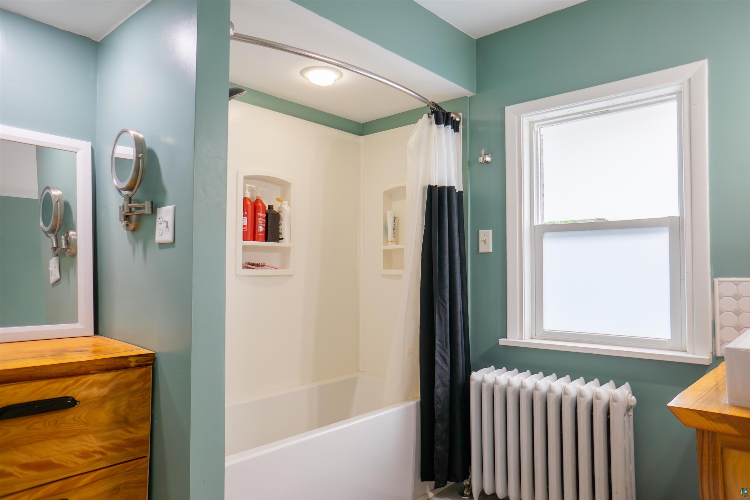 201 Snively Road Duluth, MN 55803 - Photo 11 of 21 Bathroom featuring vanity, radiator, shower / bath combo, and plenty of natural light